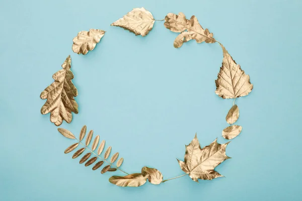 Круглая рамка осенней золотой листвы на синем фоне с копировальным пространством — стоковое фото