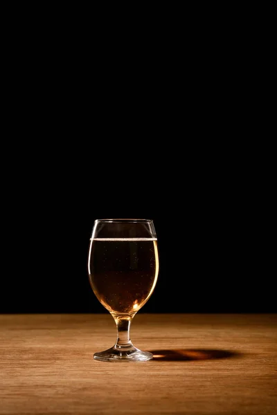 Склянка пива на дерев'яному столі ізольовано на чорному — стокове фото
