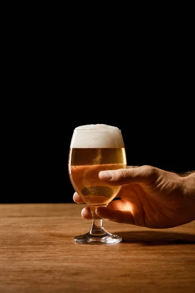 Visão parcial do homem segurando vidro de cerveja isolado em preto — Fotografia de Stock