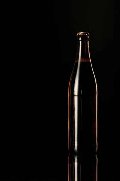 Bouteille en verre de bière isolée sur noir — Photo de stock