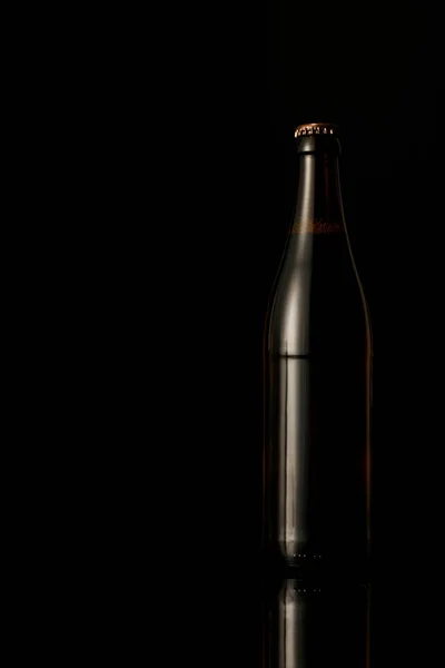 Темна скляна пляшка пива ізольована на чорному — стокове фото