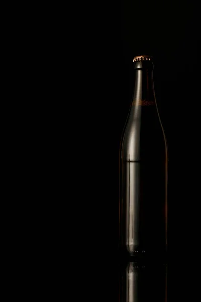 Bouteille en verre sombre de bière isolée sur noir — Photo de stock