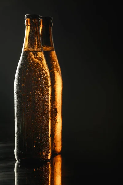 Botellas de vidrio de cerveza con gotas aisladas en negro - foto de stock