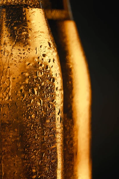 Крупним планом вид на мокрі скляні пляшки пива ізольовані на чорному — стокове фото