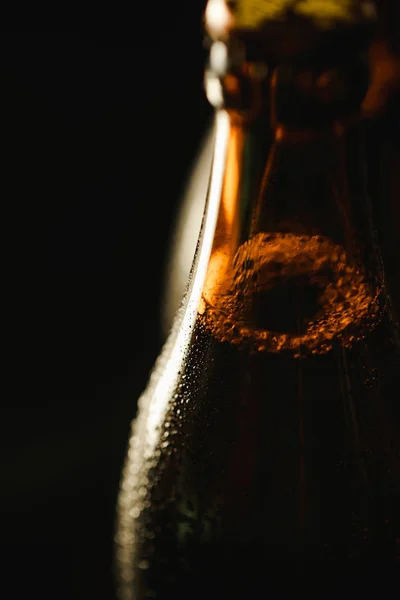Close up view of wet bottle of beer with bubbles isolated on black — Stock Photo
