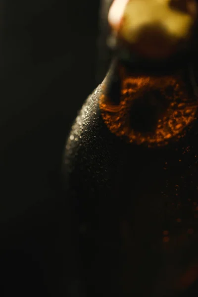 Vista de cerca de la botella húmeda de cerveza con burbujas aisladas en negro - foto de stock