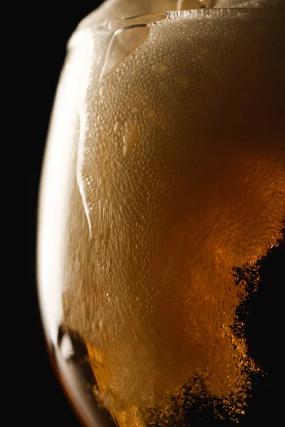 Vista ravvicinata di schiuma di birra in vetro isolato su nero — Foto stock