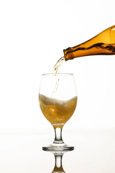 Пиво, що ллється з пляшки в склянку ізольовано на білому — стокове фото