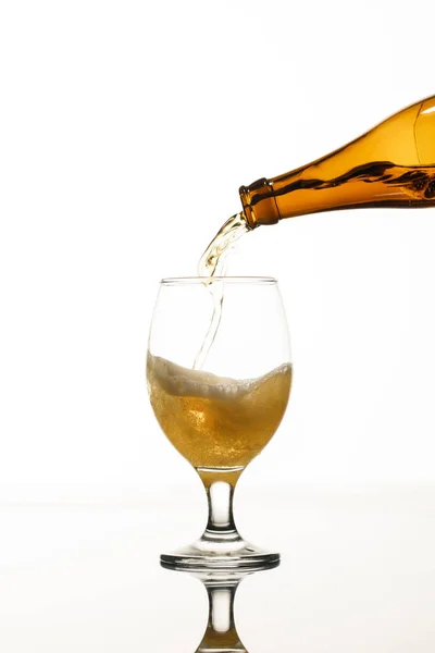 Cerveza que vierte de la botella en el vidrio aislado en blanco — Stock Photo
