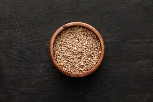 Vista superior del tazón marrón con avena cruda en la superficie de madera oscura con espacio para copiar — Stock Photo