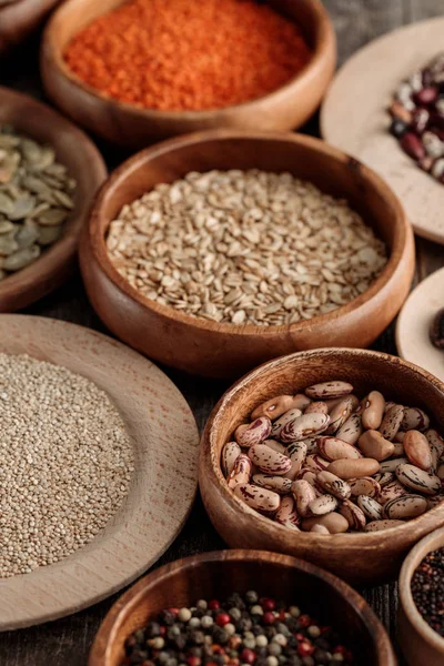 Diverse wooden bowls with beans, pumpkin seeds, lentil and cereals — Stock Photo