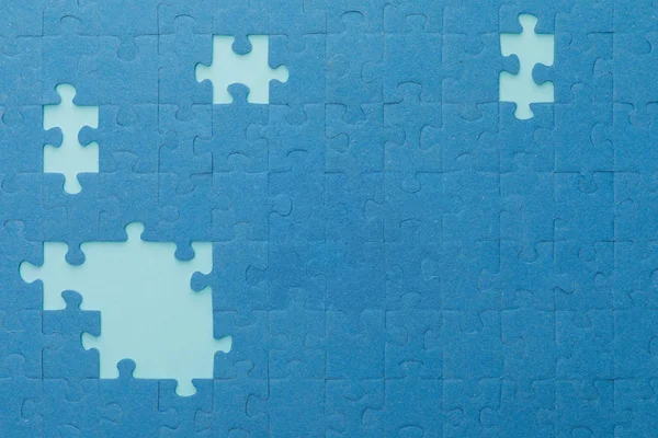 Draufsicht auf unfertiges blaues Puzzle auf hellerem Hintergrund — Stockfoto