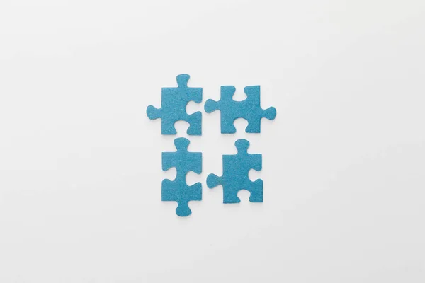 Top view of pieces of blue jigsaw puzzle on white background — Stock Photo