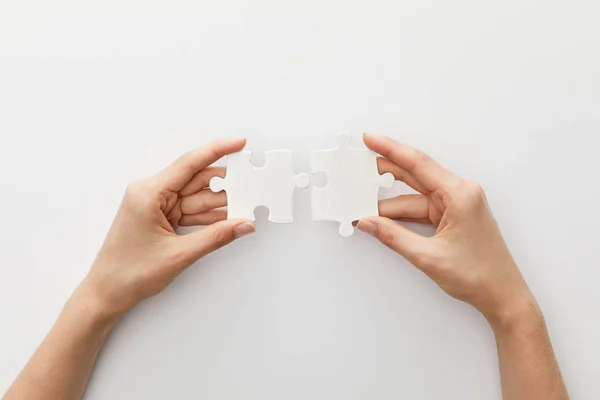 Cropped view of woman holding piece of jigsaw puzzle on white background — Stock Photo