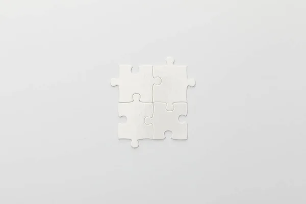 Top view of completed part of jigsaw puzzle on white background — Stock Photo