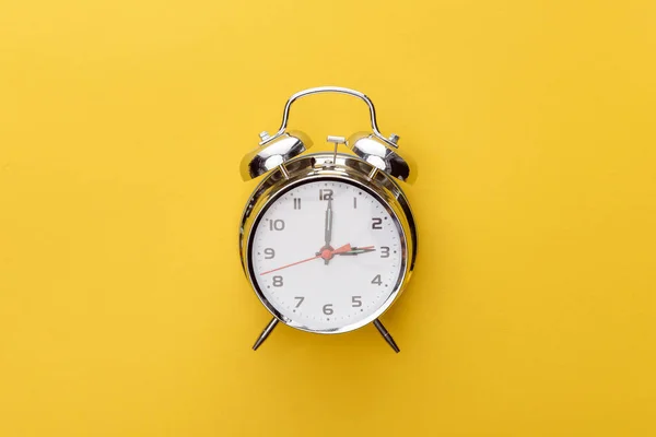 Horloge en métal vue de dessus sur fond jaune — Photo de stock