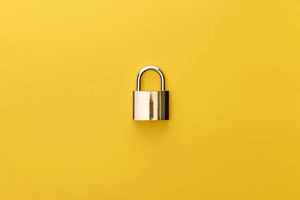 Top view of metal padlock on yellow background — Stock Photo