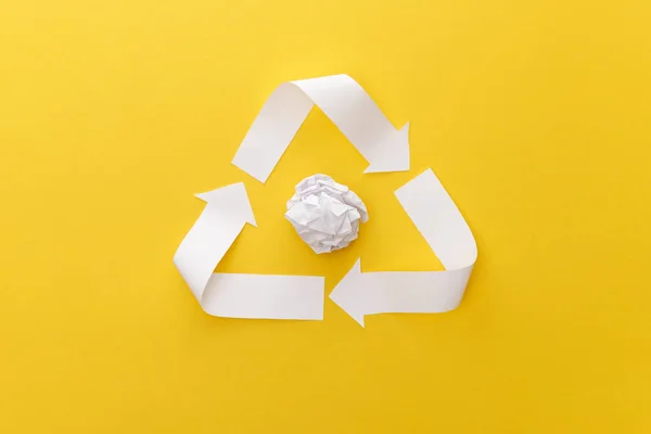 Top view of white triangle with crumpled paper on yellow background — Stock Photo