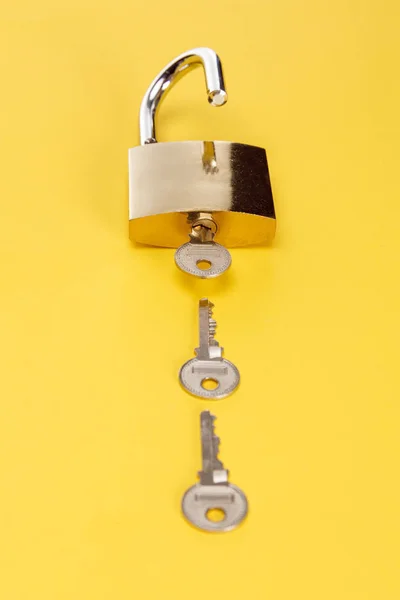 Metal padlock with keys on yellow background — Stock Photo
