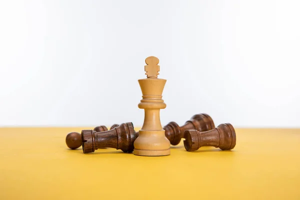 Schachfiguren auf gelber Fläche isoliert auf weißer Fläche — Stockfoto