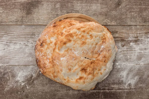 Top view of round lavash bread on wooden table — Stock Photo