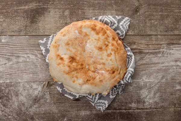 Vue du dessus du pain lavash sur une serviette grise avec motif sur une table en bois — Photo de stock