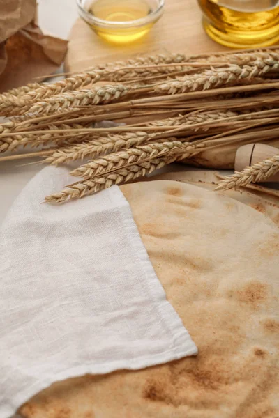 Pain lavash recouvert de serviette blanche près du rouleau à pâtisserie, des pointes et de l'huile — Photo de stock