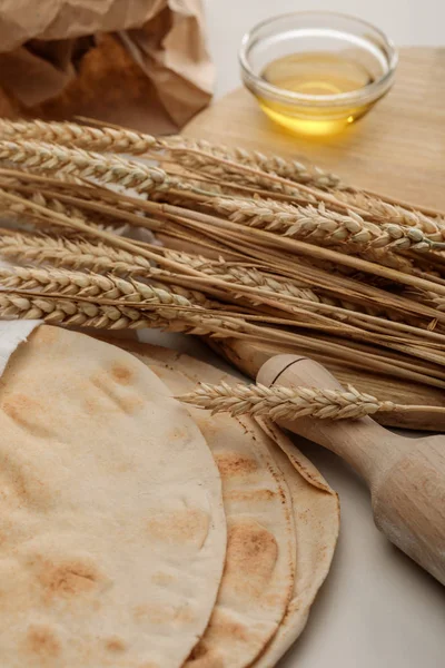 Pain lavash près de rouleau à pâtisserie et planche à découper avec pointes et huile — Photo de stock