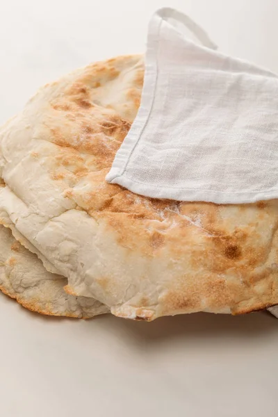 Лавашний хліб, покритий рушником на білій поверхні — стокове фото