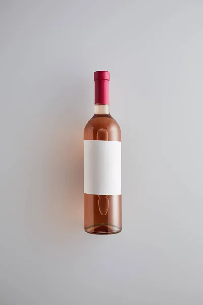 Vista dall'alto della bottiglia con vino rosato ed etichetta bianca su sfondo bianco — Foto stock