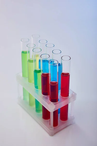 Tubes à essai en verre avec liquide coloré sur fond blanc — Photo de stock