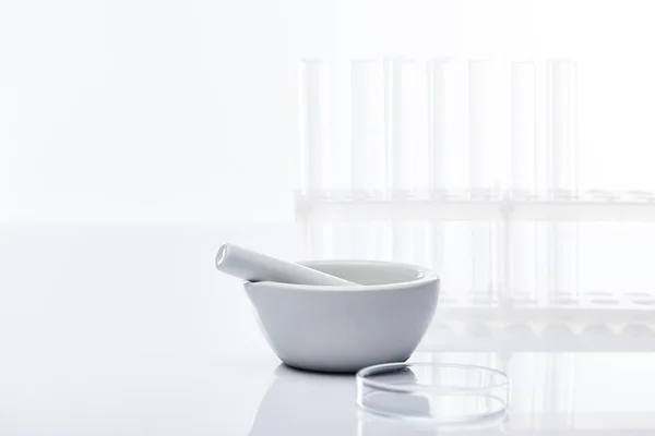 Tubos de ensaio de vidro vazios e argamassa com pilão isolado sobre branco — Fotografia de Stock