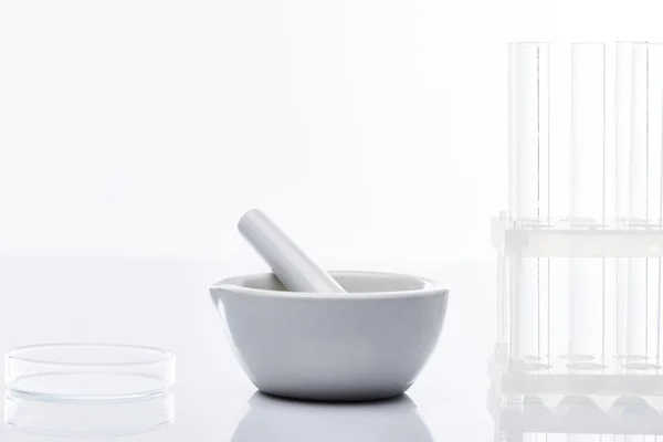 Empty glass test tubes and mortar with pestle isolated on white — Stock Photo