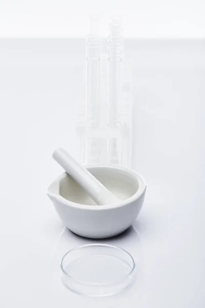 Empty glass test tubes and mortar with pestle isolated on white — Stock Photo