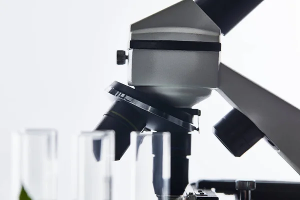 Selective focus of glass test tubes and microscope isolated on white — Stock Photo