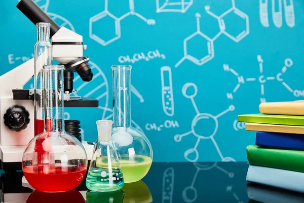 Bücher, Mikroskop, Glas-Reagenzgläser und Kolben mit bunter Flüssigkeit auf blauem Hintergrund mit molekularer Struktur — Stockfoto