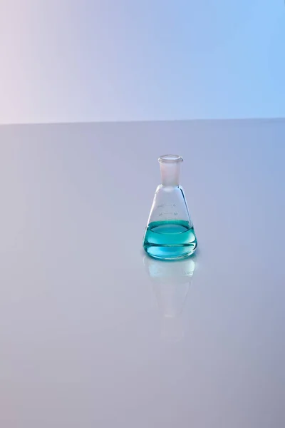 Glass flask with blue colorful liquid — Stock Photo