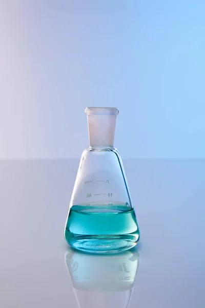 Glass flask with blue colorful liquid — Stock Photo