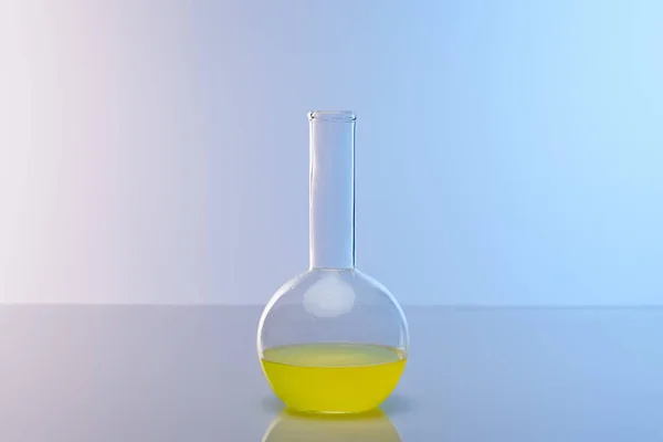 Glass flask with colorful yellow liquid — Stock Photo
