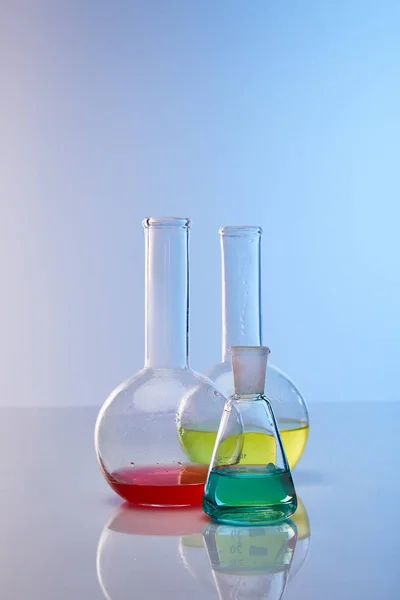 Glass flasks with colorful yellow, blue and red liquid — Stock Photo