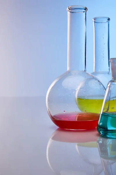 Glass flasks with colorful yellow, blue and red liquid — Stock Photo