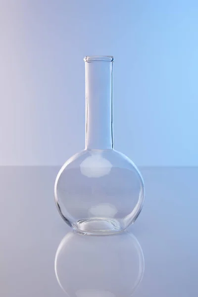 Empty clean glass flask on blue background — Stock Photo