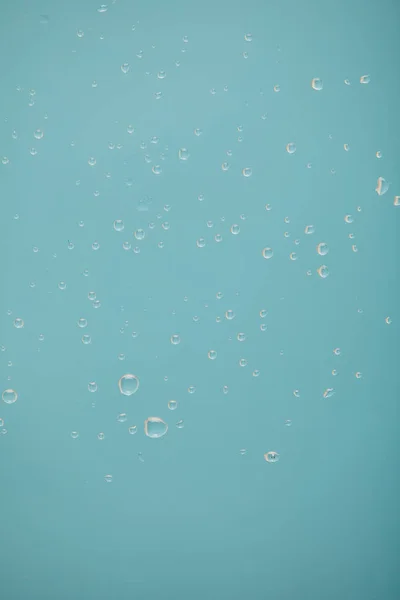 Gotas de agua clara sobre fondo azul - foto de stock