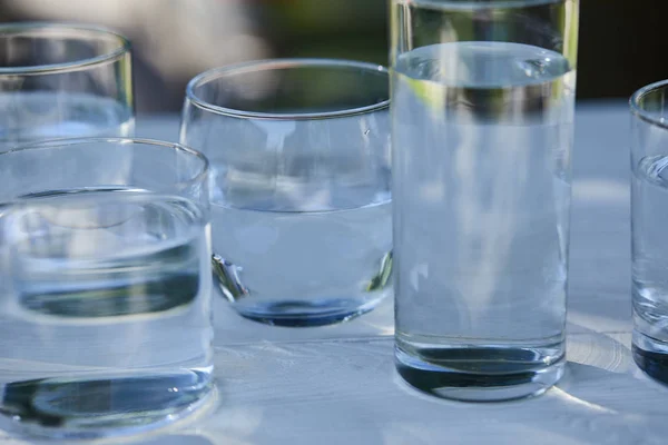 Clear fresh water in transparent glasses on wooden table — Stock Photo