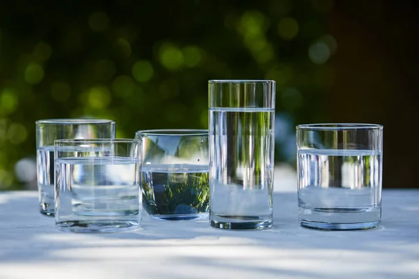 Eau douce claire dans des verres transparents à la lumière du soleil — Photo de stock