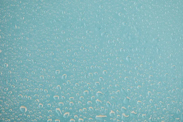 Gotas de agua transparentes sobre fondo azul - foto de stock