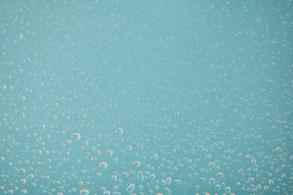 Прозорі прозорі краплі води на світло-блакитному фоні — стокове фото