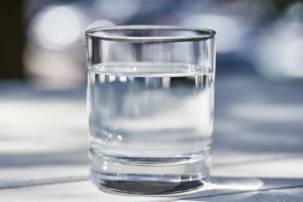 Frisches sauberes Wasser in transparentem Glas an sonnigen Tagen draußen — Stockfoto