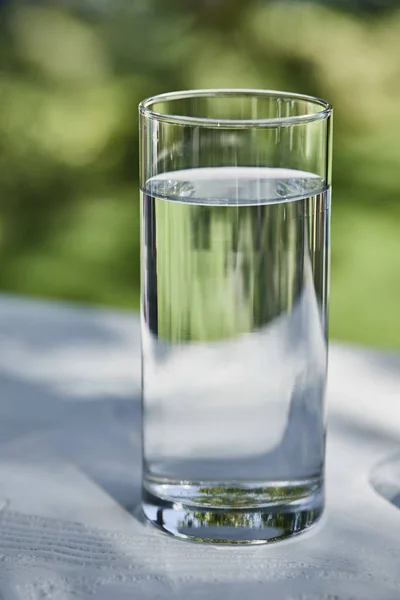 Frisches sauberes Wasser in transparentem Glas an sonnigen Tagen draußen — Stockfoto