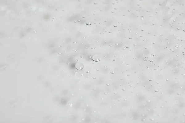 Прозорі прозорі краплі води на білому тлі — стокове фото